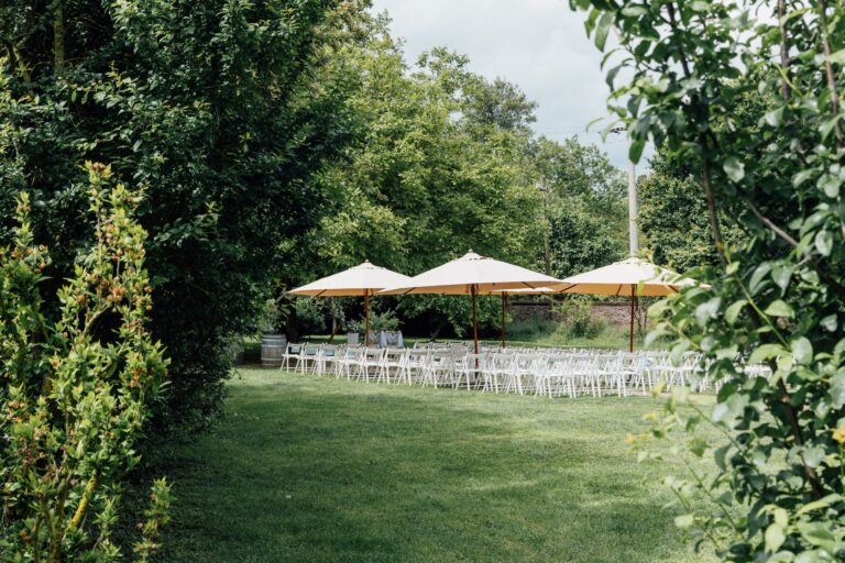 Der Garten mit Sonnenschirmen und Stuhlreihen vor der Trauung
